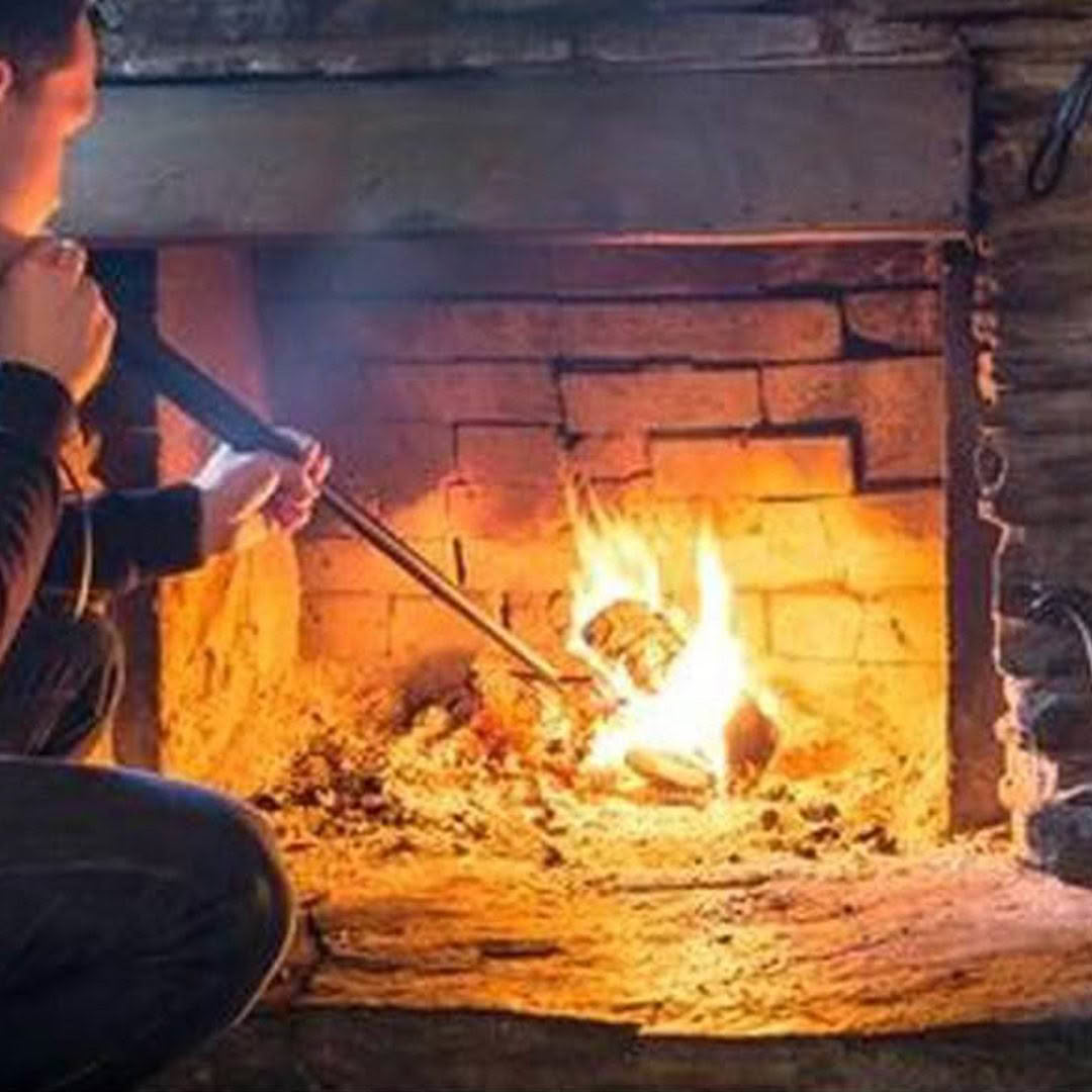 Person roasting marshmallows by a cozy fireplace