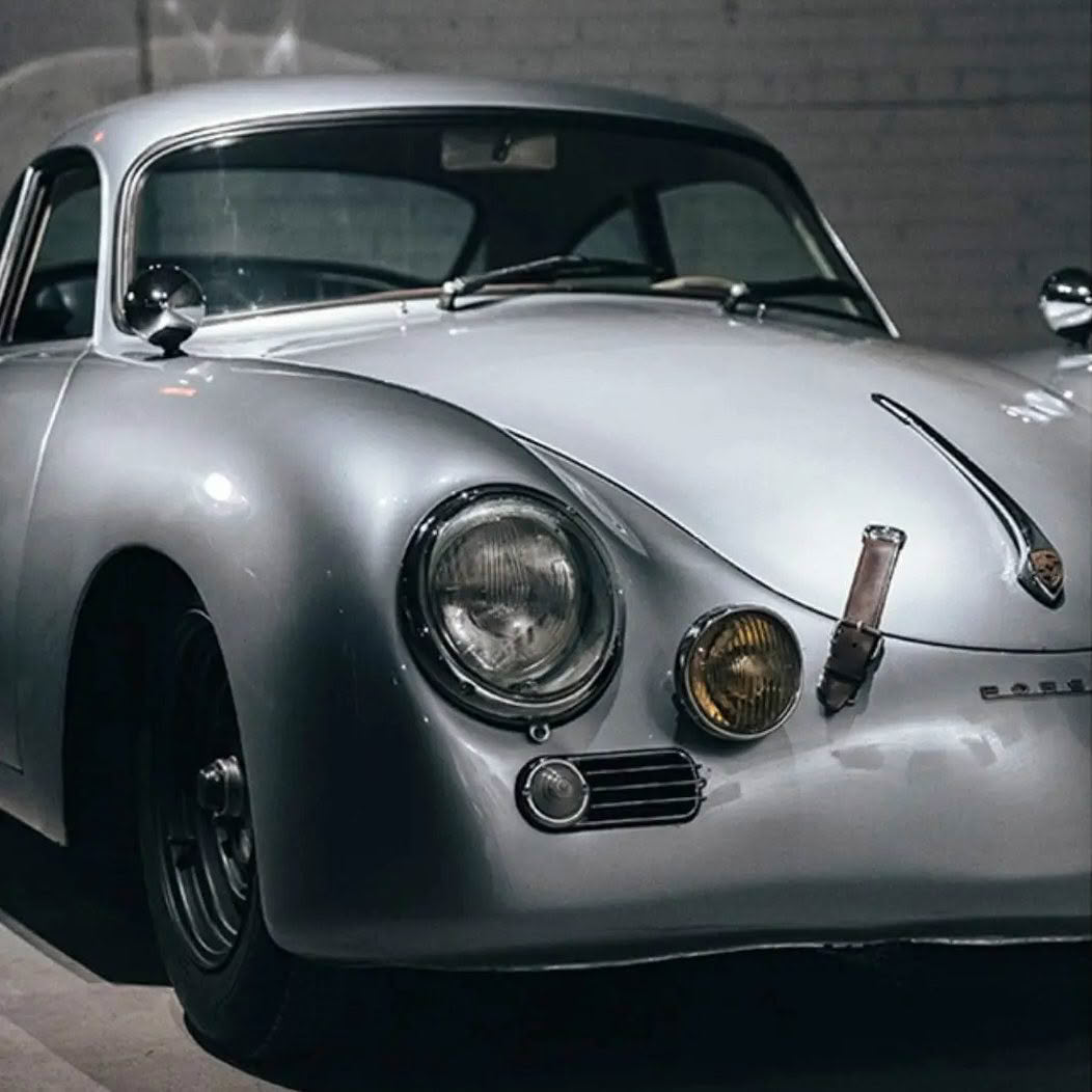 Vintage Porsche 356 silver coupe in dimly lit garage