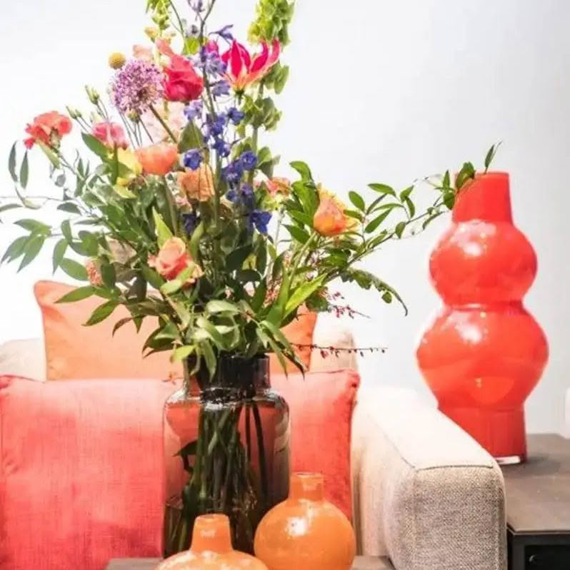 Colorful bouquet on table with red and orange decor