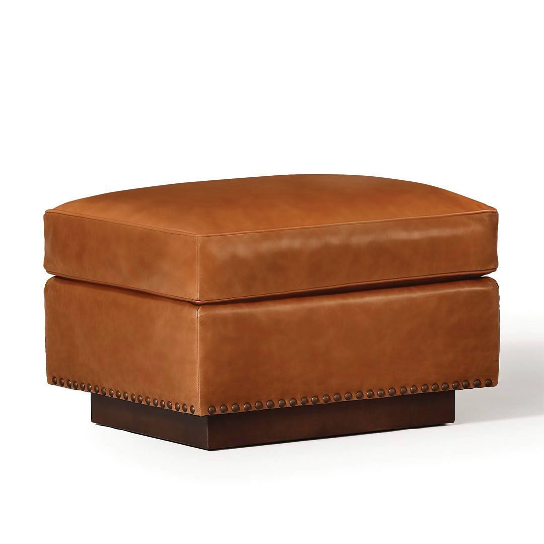 Brown leather ottoman with nailhead trim