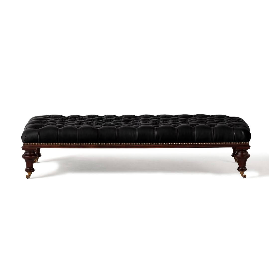 Black tufted leather bench on carved wooden legs