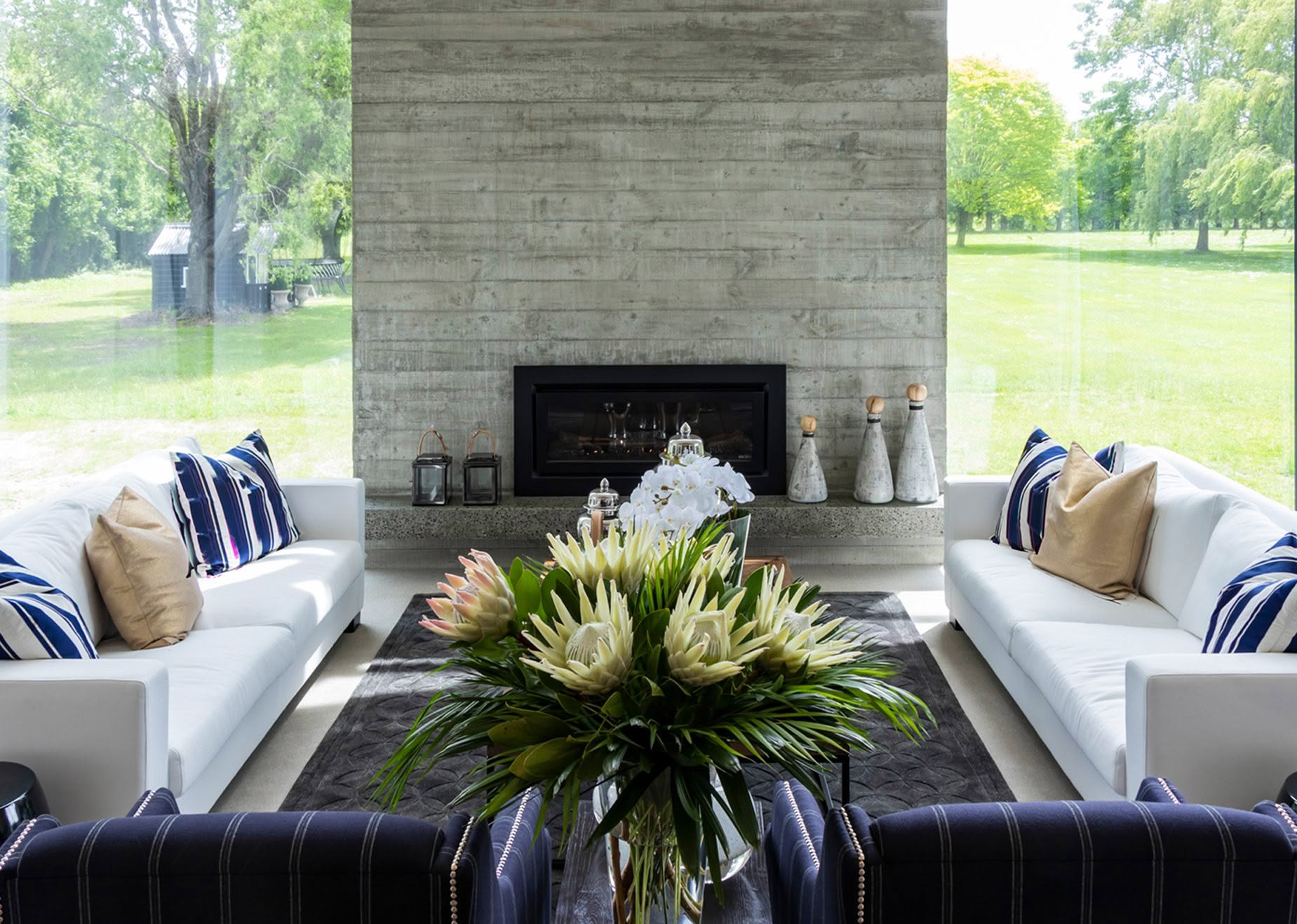 Modern living room with concrete fireplace and garden view