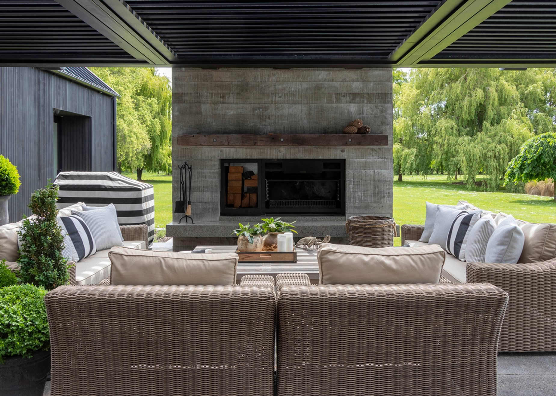 Outdoor patio with wicker furniture and modern fireplace