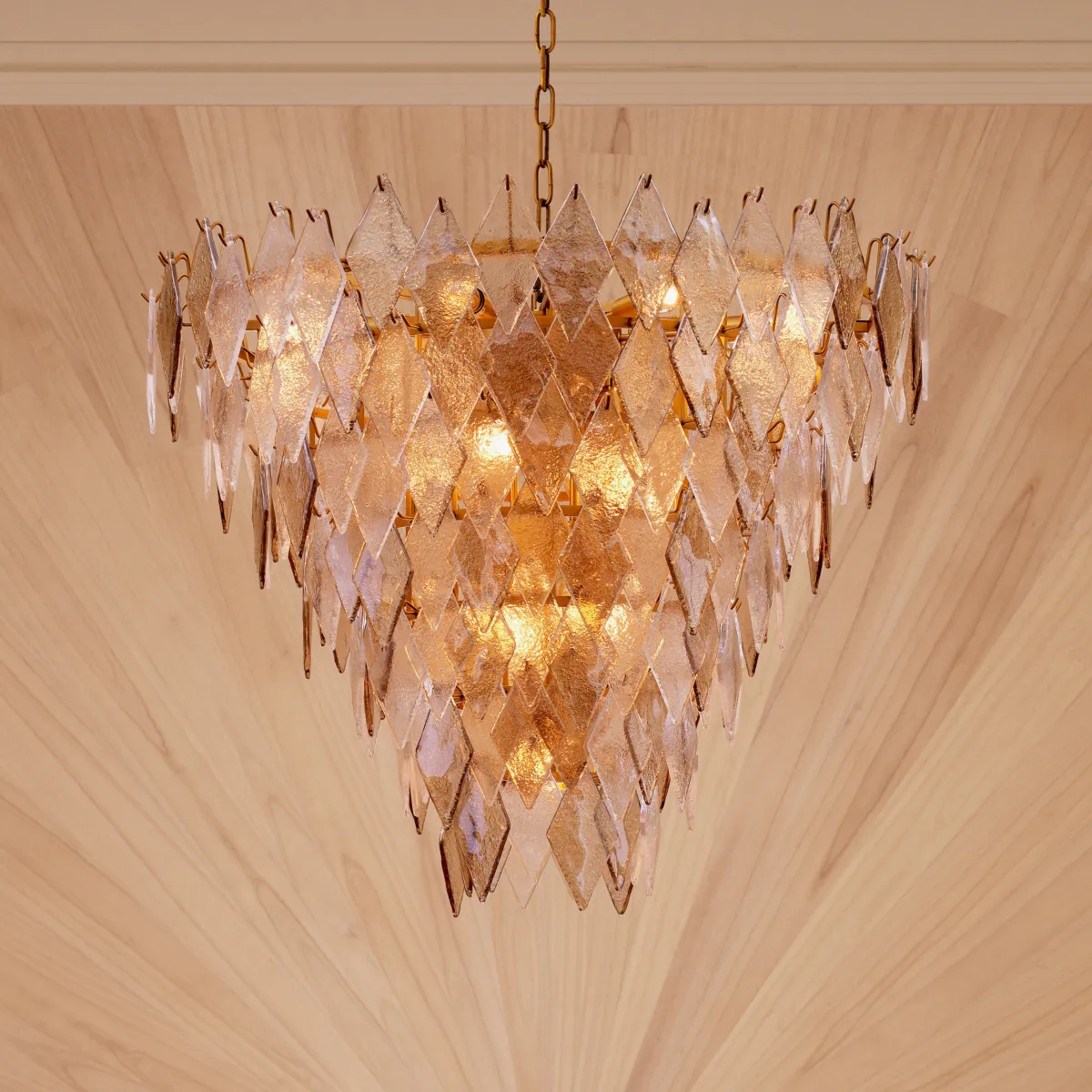 Illuminated gold leaf chandelier hanging from ceiling