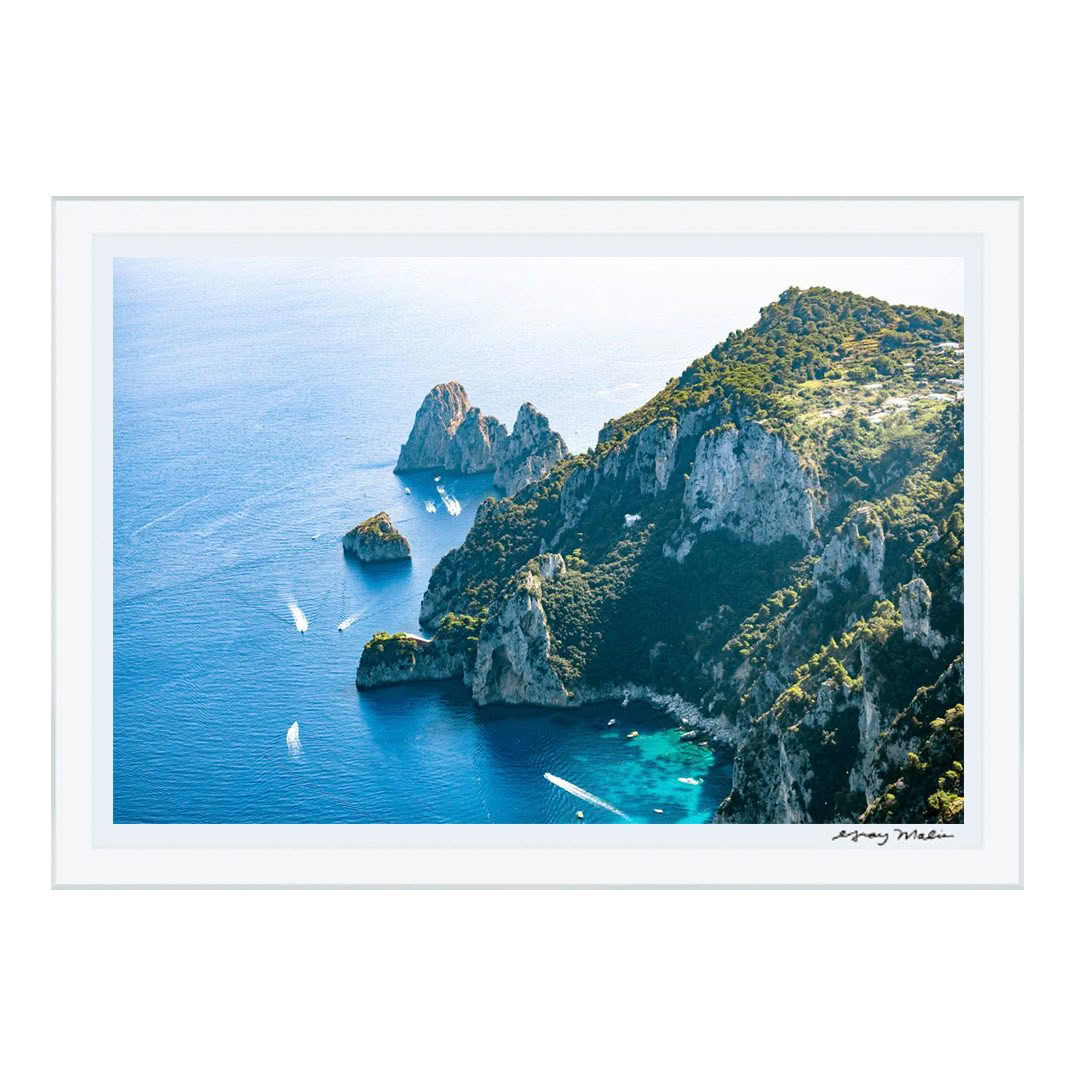 Aerial view of rocky cliffs and blue sea with boats