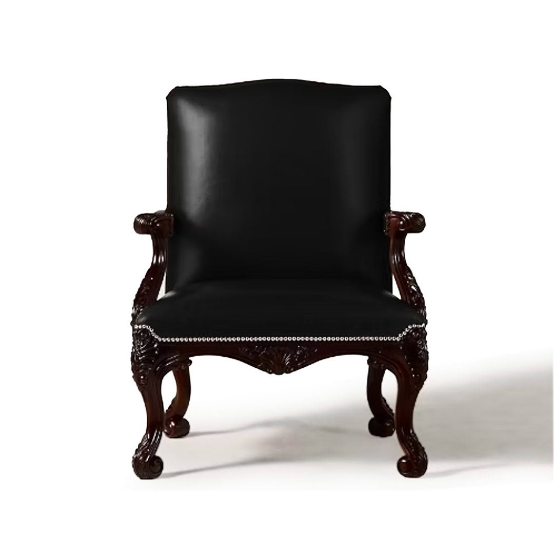 Ornate black leather upholstered armchair with carved wooden legs