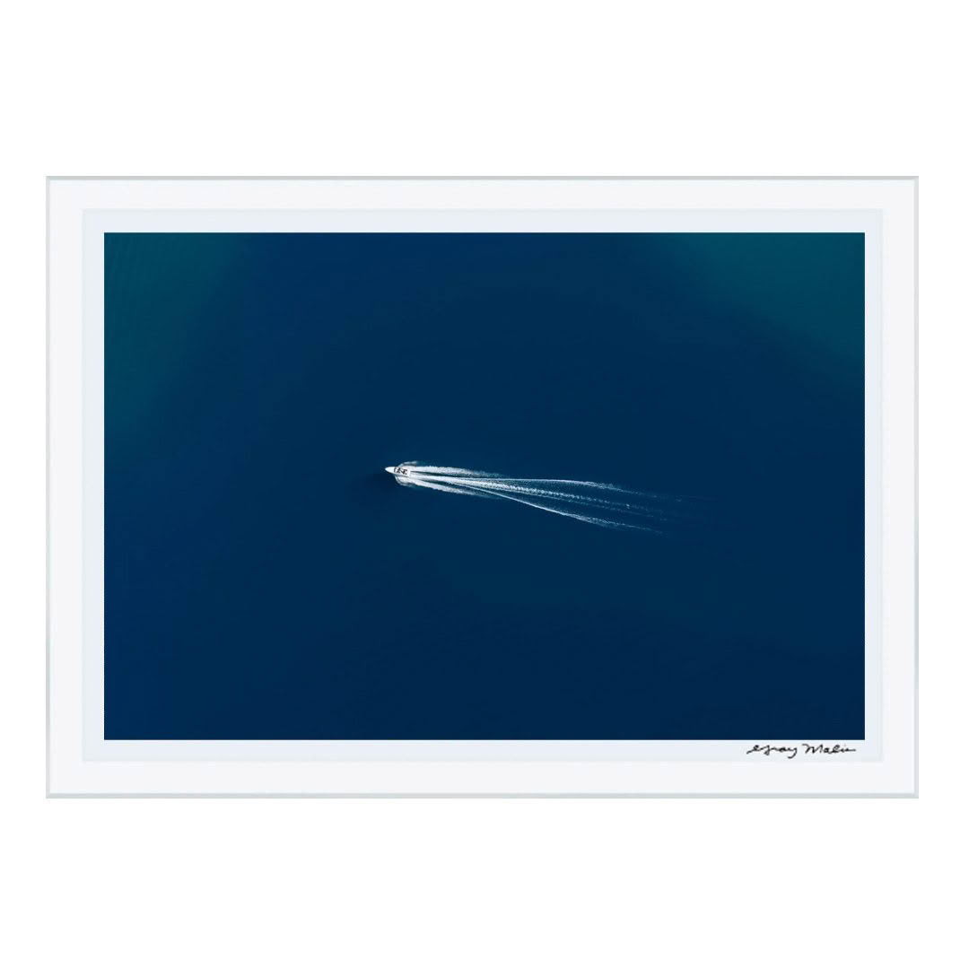 Boat leaving white trail on deep blue ocean