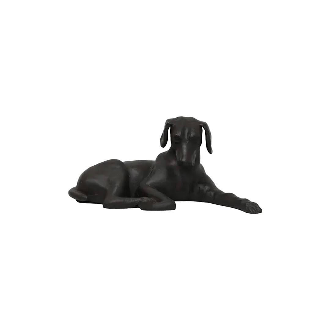 Black sculpted dog lying down isolated on white