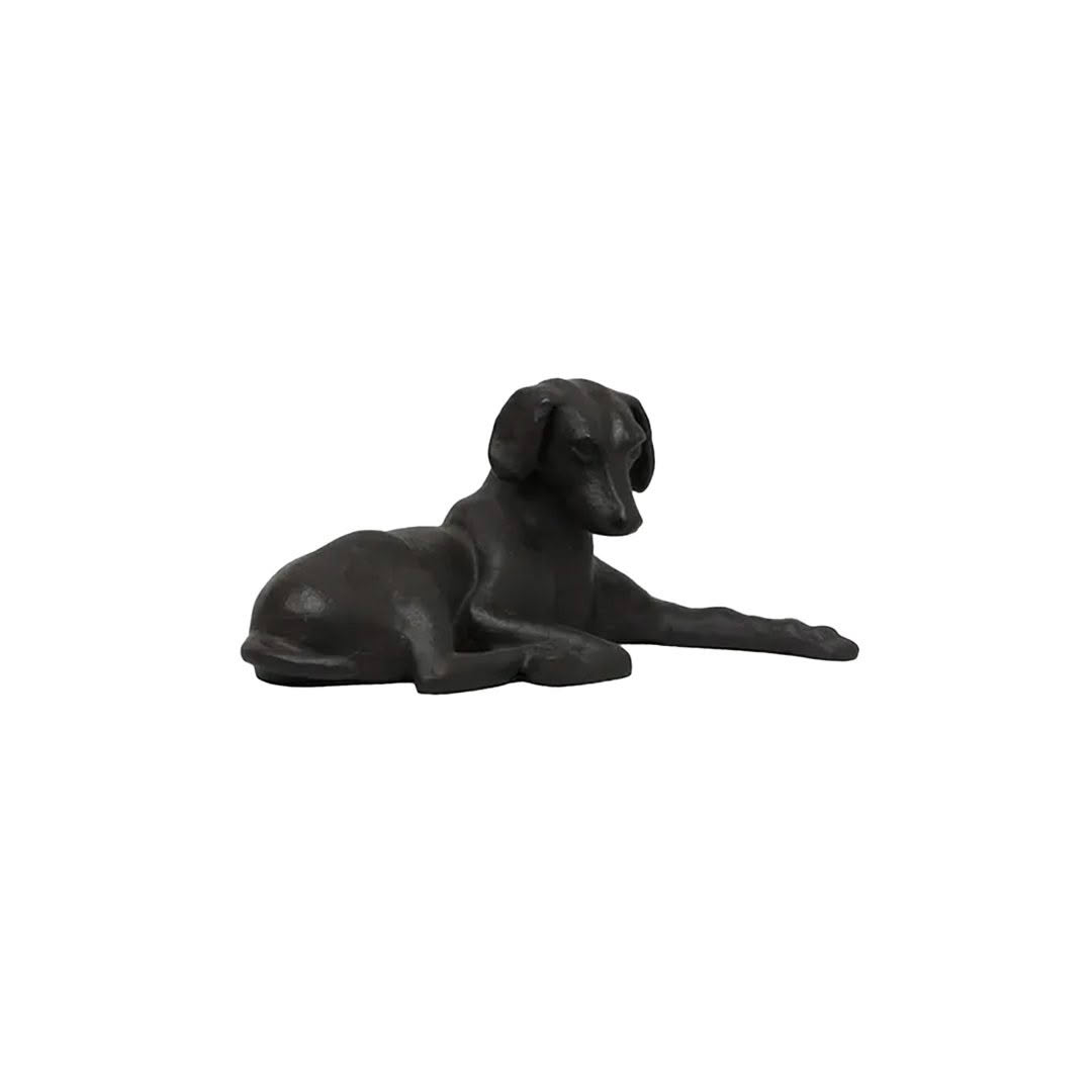Black dog figurine lying down isolated on white