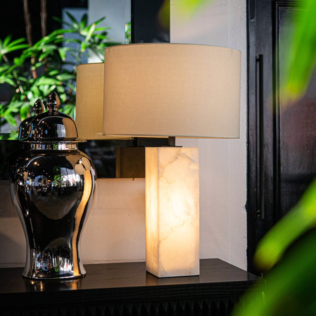 Marble lamp next to shiny black ceramic vase