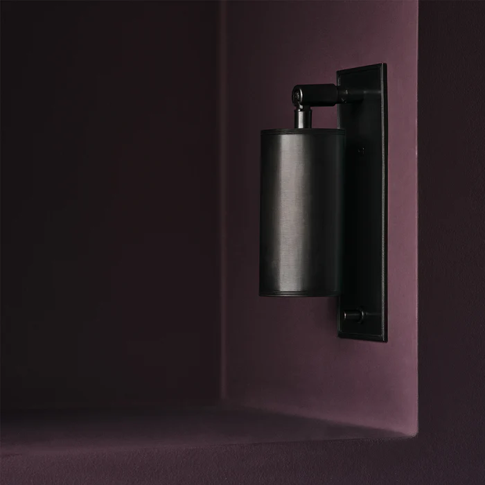 Modern black wall-mounted lamp on purple background
