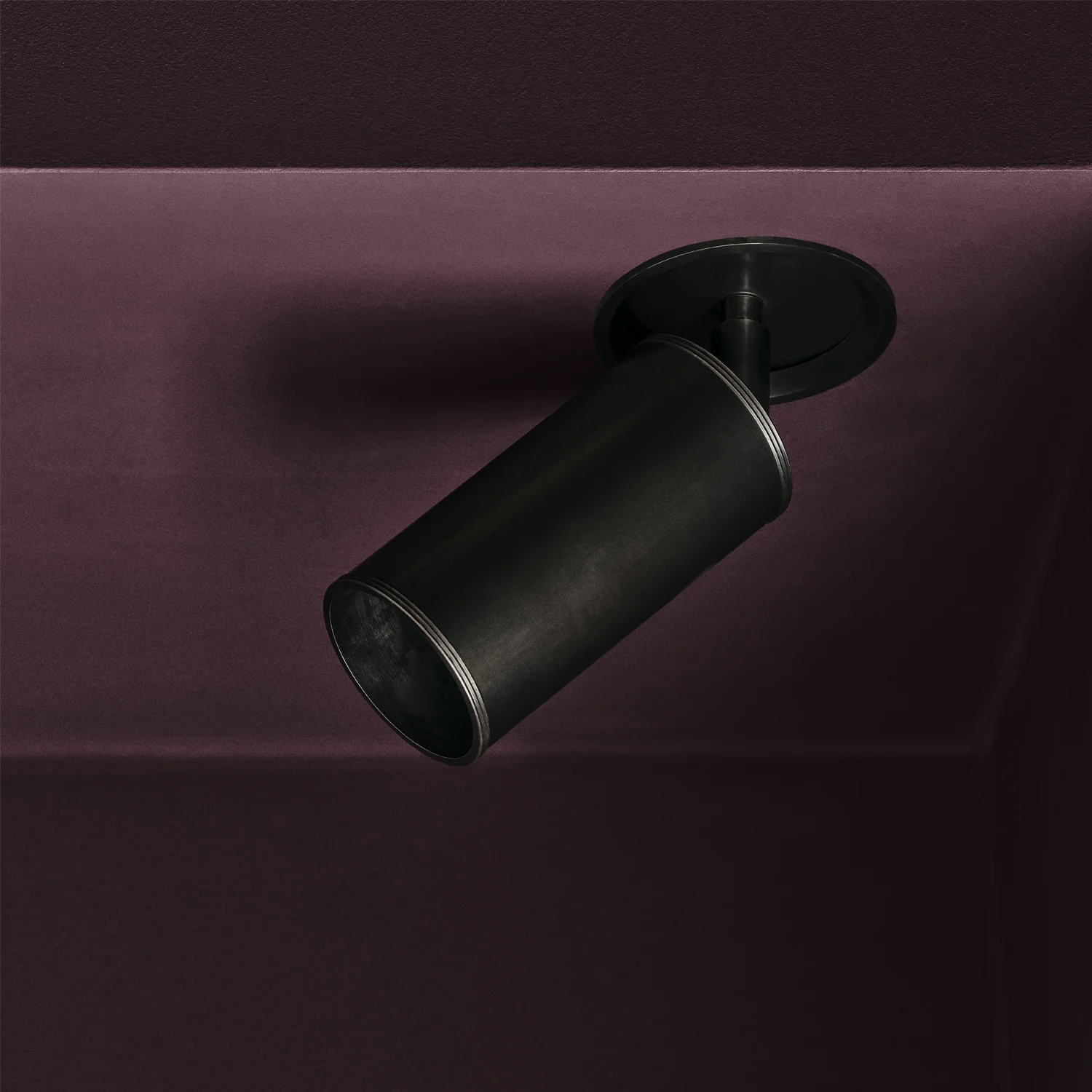 Black ceiling light fixture on maroon background